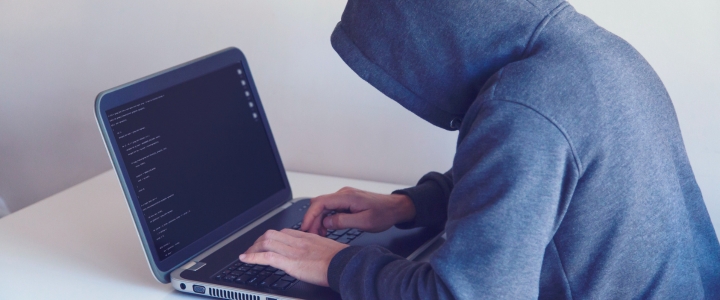 Cyber Hacker on laptop in white room.